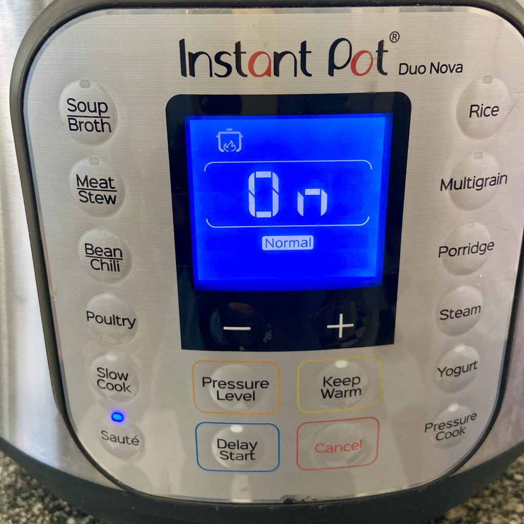 Picture of an instant pot with the saute function button lit up