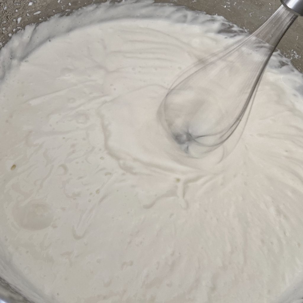 Homemade yogurt being whipped smooth by a whisk