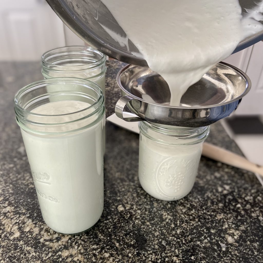 Yogurt being poured from an instant pot into jars