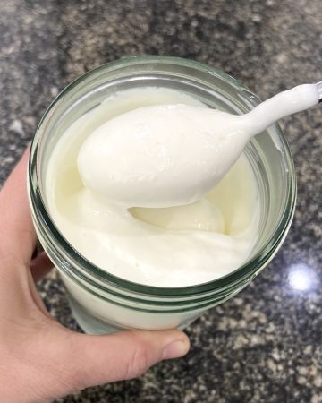Yogurt in a jar, being scooped up by a spoon